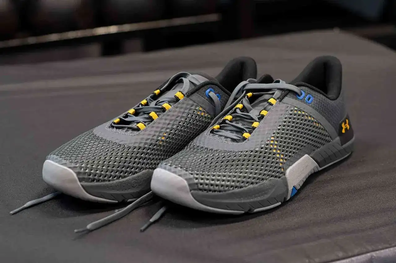 Szare buty do crossfitu z żółtymi akcentami i siateczkową cholewką. Idealne na treningi.